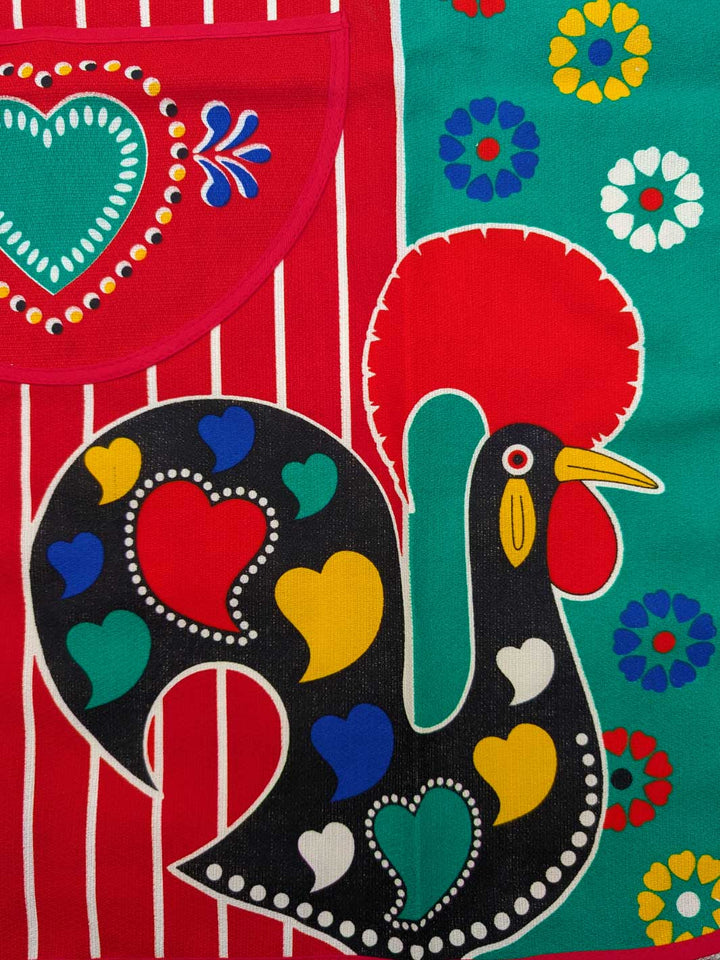 Colorful fabric with rooster design on a red and green background