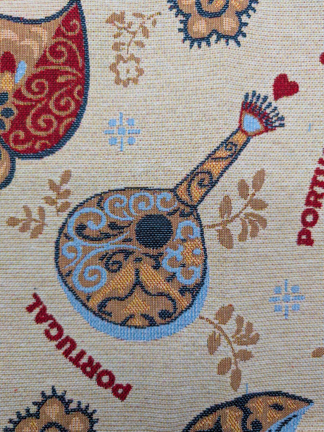 Decorative fabric with musical instrument design and 'Portugal' text