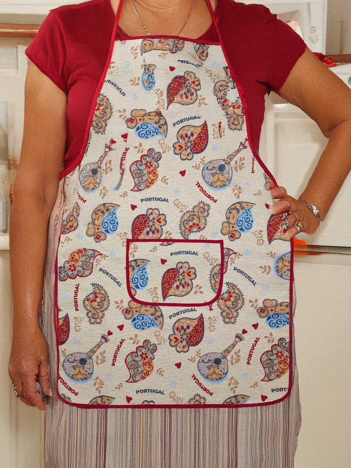 Person wearing a colorful apron with Portuguese-themed designs in a kitchen.
