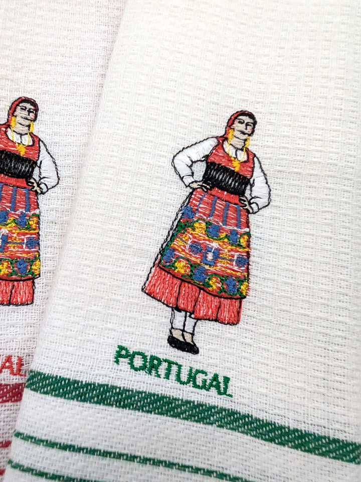 Embroidered design of a traditional Portuguese costume on a white fabric with 'Portugal' text.