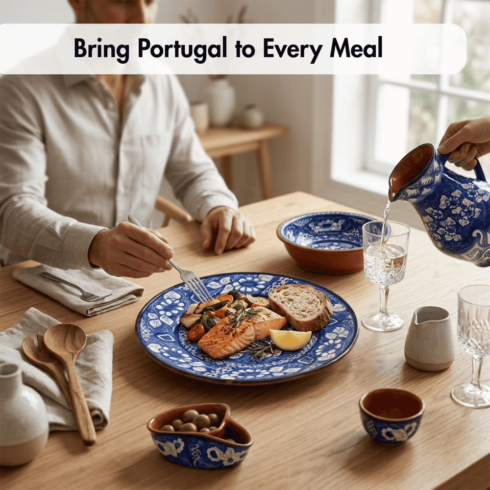 A lifestyle dining scene showing a person seated at a wooden table with a blue and white patterned plate of salmon, bread, and vegetables, while another hand pours water from a matching blue and white ceramic pitcher. The text overlay reads 'Bring Portugal to Every Meal'.
