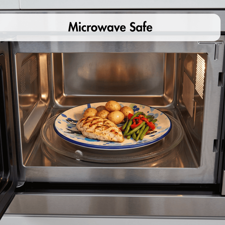 A microwave oven door is open, showing a plate with cooked chicken, potatoes, green beans, and red peppers on the glass turntable inside. A white banner at the top reads &