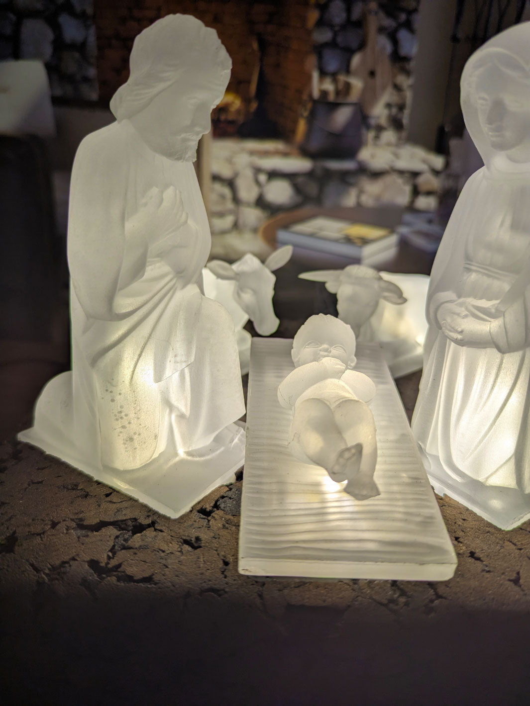 White ceramic nativity scene with three figures on a textured surface.