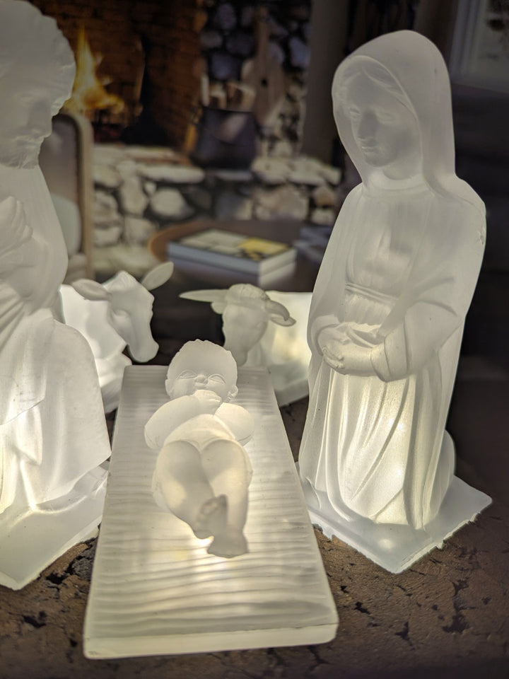 Decorative nativity scene with illuminated figures of Mary, Joseph, and baby Jesus.
