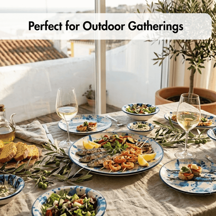 Outdoor dining table set with blue and white patterned plates, wine glasses, olive oil, bread, and seafood on a linen tablecloth, with the text &