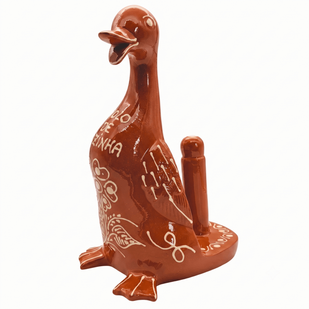A glossy terracotta-colored ceramic duck-shaped object with white decorative markings and the word 'DINHA' on its side, shown against a plain white background.