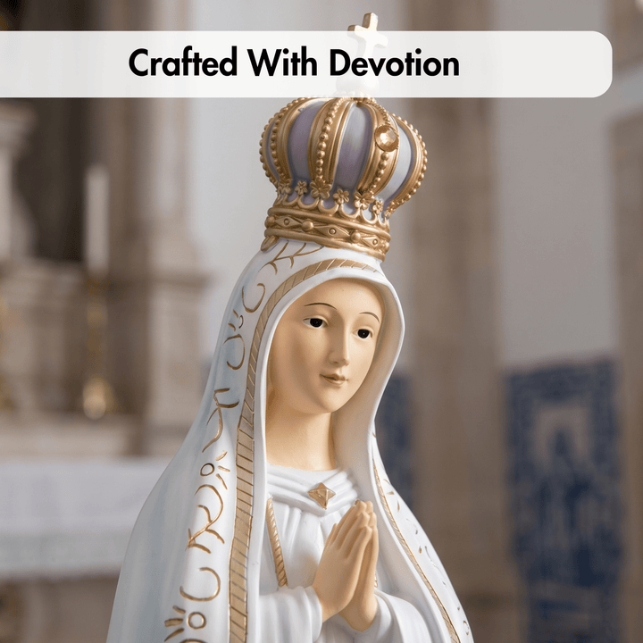 A devotional figurine of the Virgin Mary wearing a gold crown and white veil with gold detailing, shown against a softly blurred church interior. A white banner at the top reads &