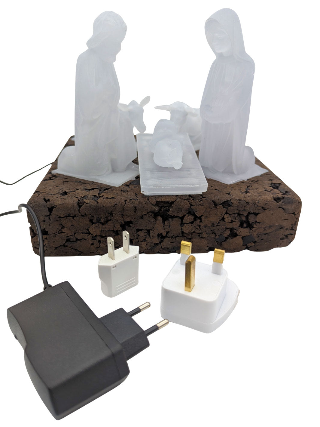 White nativity scene on a cork base with electrical plugs and sockets.