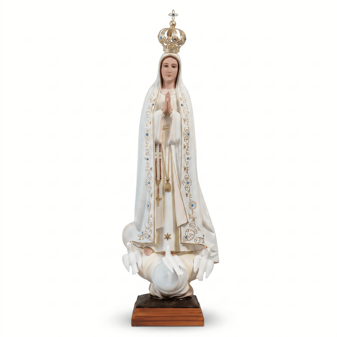 A religious statue of the Virgin Mary standing on a pedestal, wearing a white robe with gold and blue embroidery, a gold crown, and holding a rosary, photographed against a plain white background.