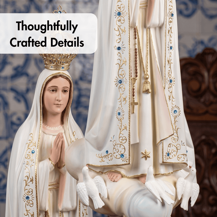 A close-up of a religious statue showing the Virgin Mary with a gold crown and white robe decorated with gold and blue embroidery, alongside a child figure in a white mantle with gold detailing. A text overlay reads &
