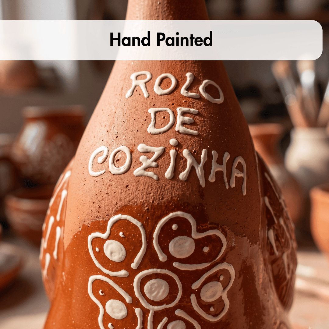 A close-up of a hand-painted terracotta-colored ceramic kitchen towel or cloth with white painted text reading &