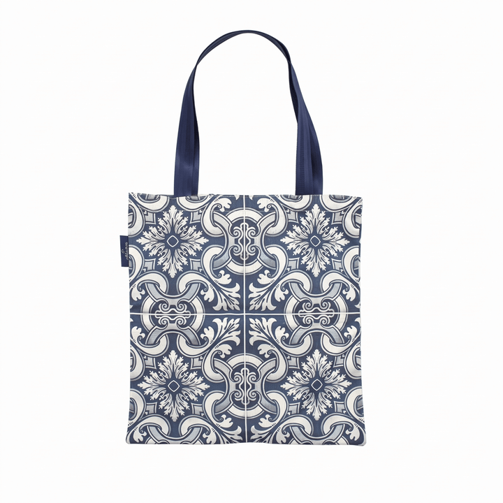 A tote bag with a navy blue and white floral tile pattern, featuring dark navy blue shoulder straps, shown against a plain white background.
