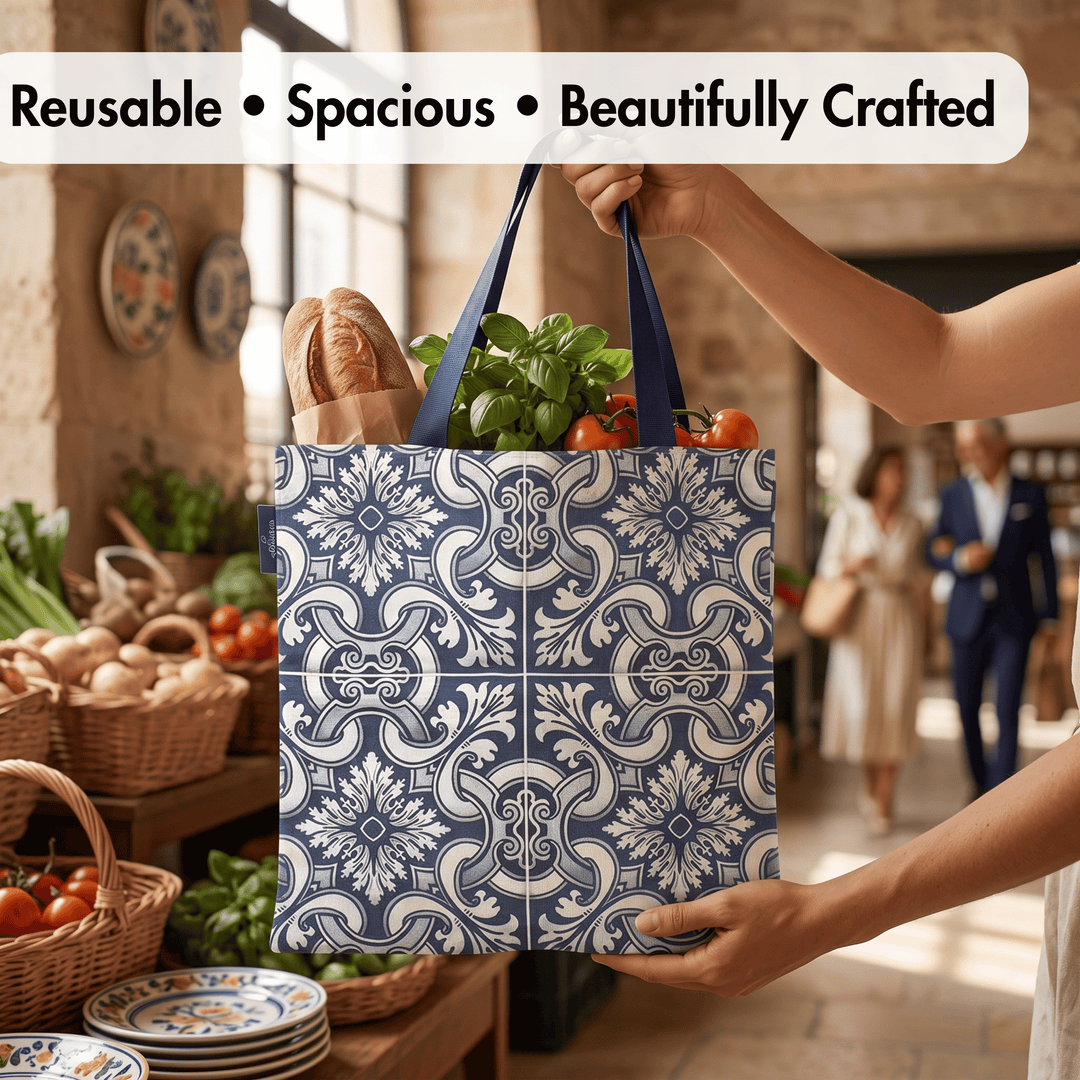 A reusable tote bag with a blue and white floral tile pattern is being held by a person in a market setting, filled with groceries like bread, basil, and tomatoes. Text at the top reads &