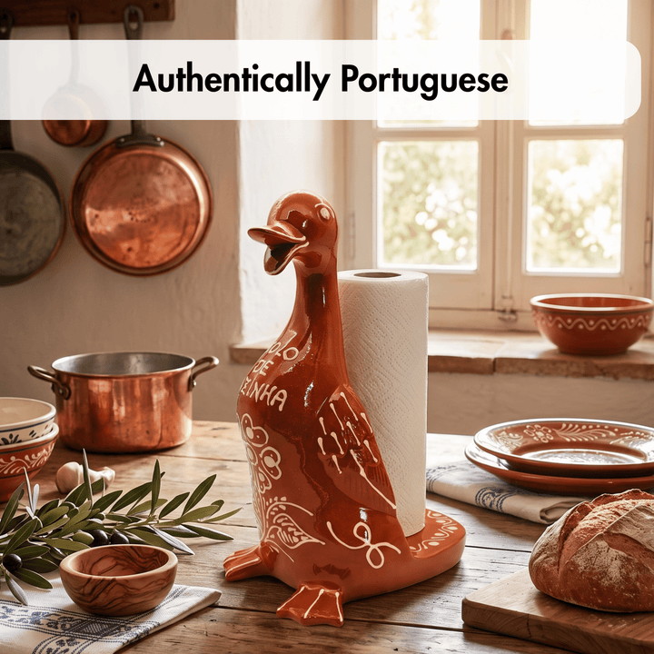 A ceramic paper towel holder shaped like a duck, painted in a warm terracotta orange with white decorative patterns and the word &