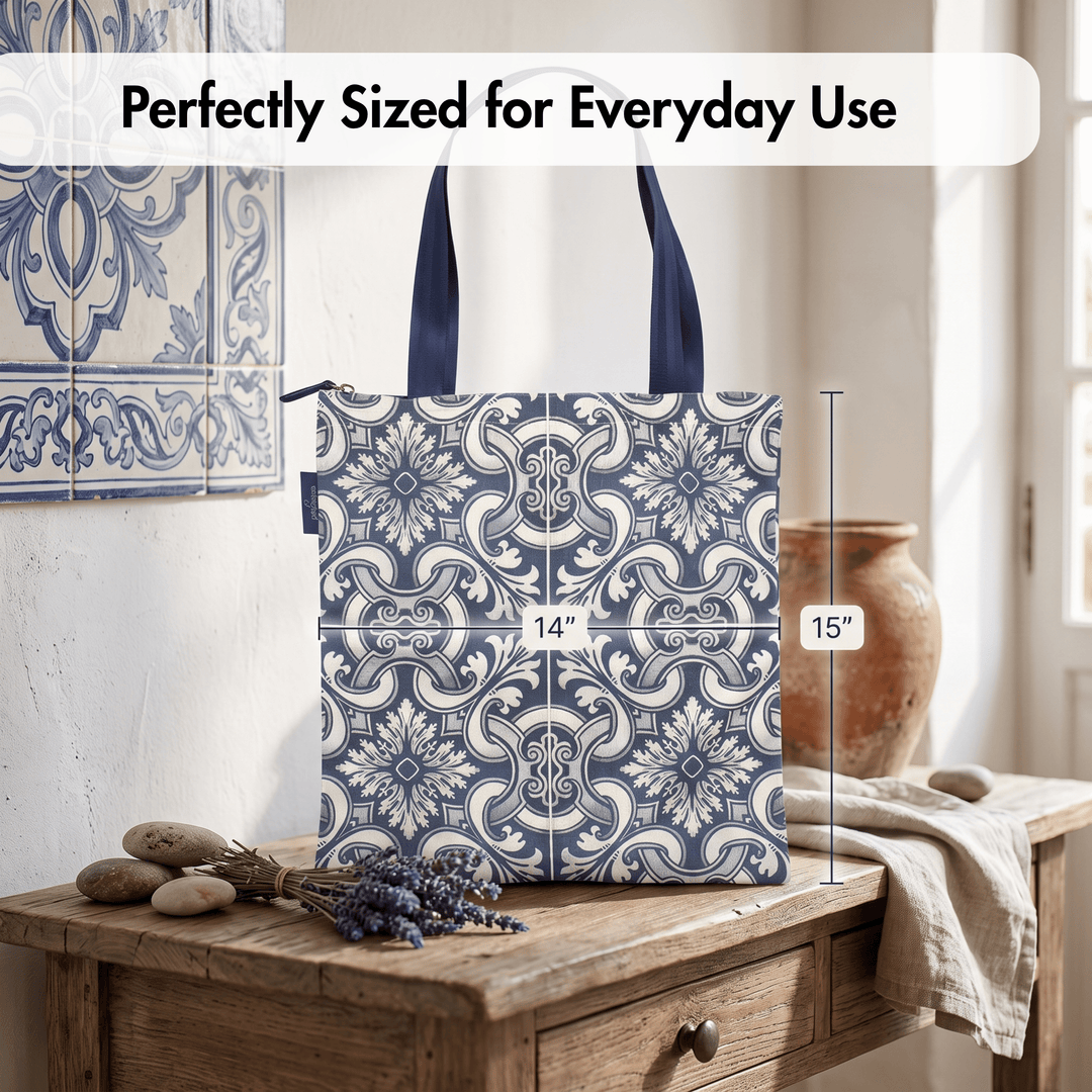 A tote bag with a blue and white floral tile pattern is shown standing on a wooden table in a styled interior. White text at the top reads &