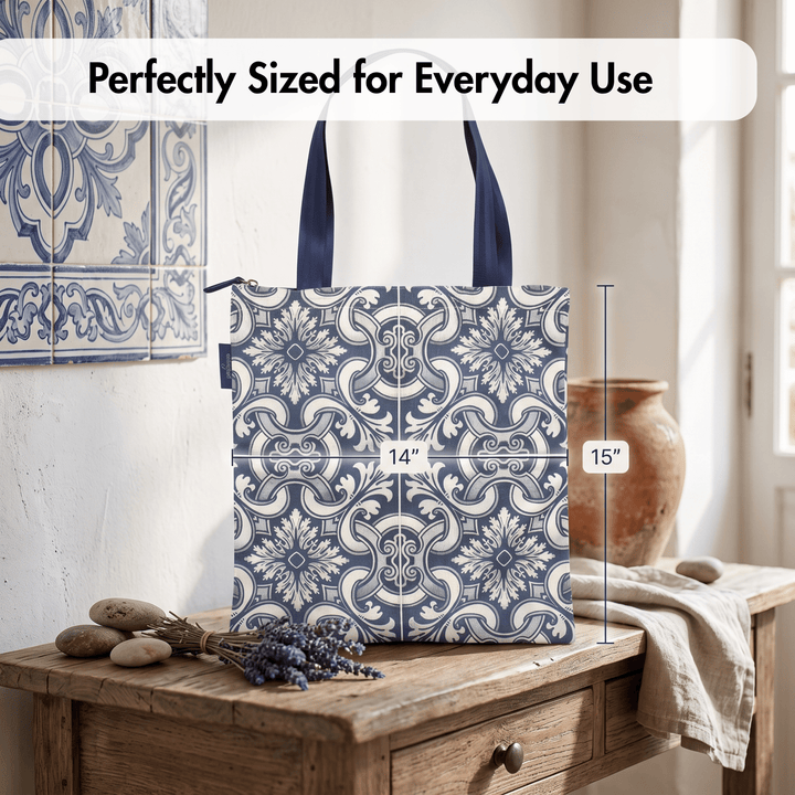 A tote bag with a blue and white floral tile pattern is shown standing on a wooden table in a styled interior. White text at the top reads &