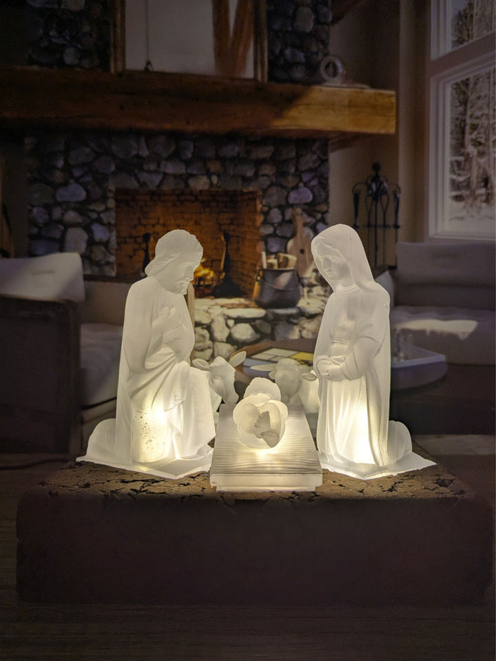 Decorative nativity scene with illuminated figures in a cozy room.
