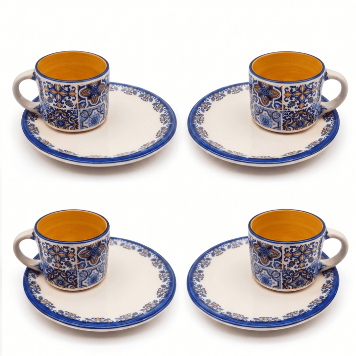 Set of four ceramic cups and saucers with blue and orange patterns on a white background