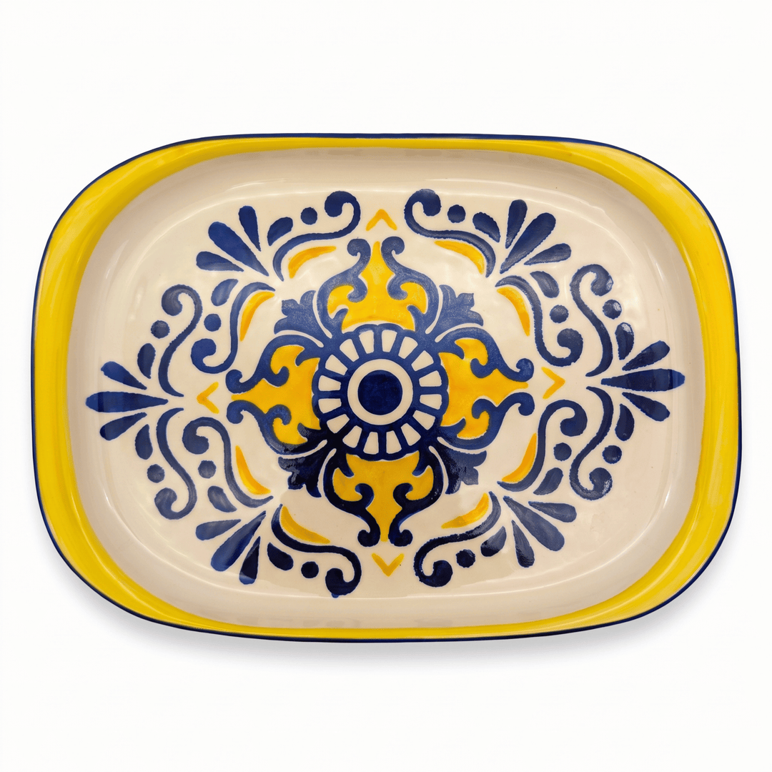 A rectangular ceramic serving platter with rounded corners, featuring a hand-painted Mediterranean style design with a yellow border, navy blue scrollwork, and a yellow central medallion on a cream-colored glaze.