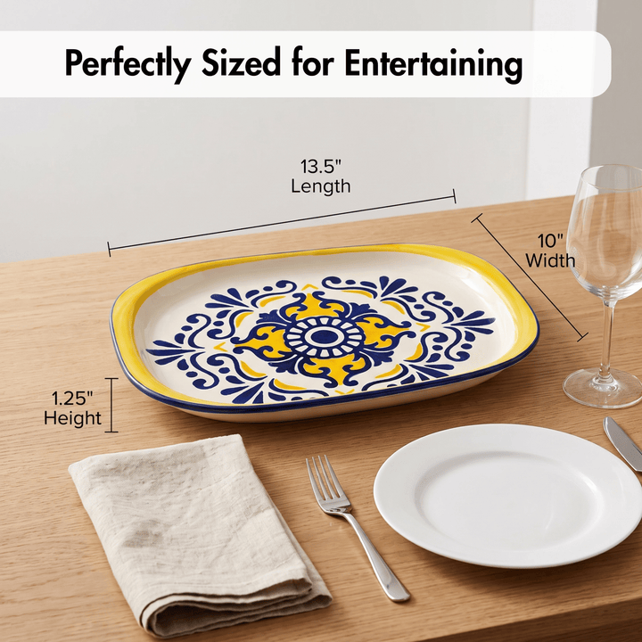 A decorative oval serving platter with a yellow and blue floral medallion pattern on a cream background, shown on a wooden table with size callouts reading 13.5 inches length, 10 inches width, and 1.