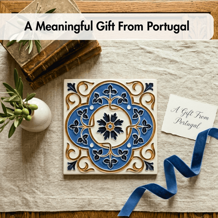 Decorative tile with intricate blue and gold design on a wooden surface with a plant and card.
