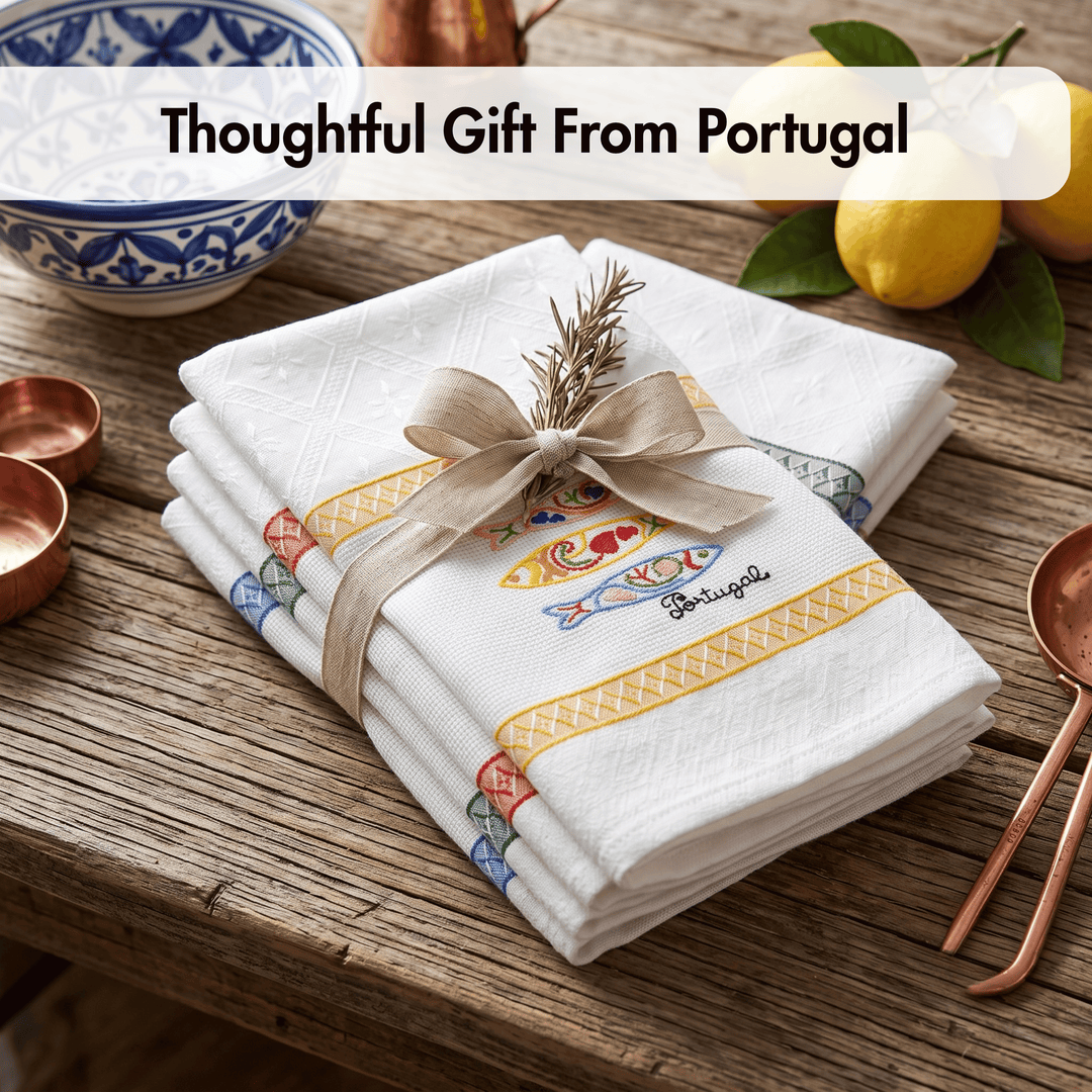 A stack of white Portuguese handkerchiefs tied with a beige ribbon and decorated with a small sprig, displayed on a rustic wooden table with lemons and copper-toned utensils. A text overlay at the top reads &
