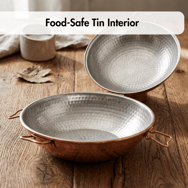 Portuguese Cataplana open with tin interior, shown on a rustic wooden table. 