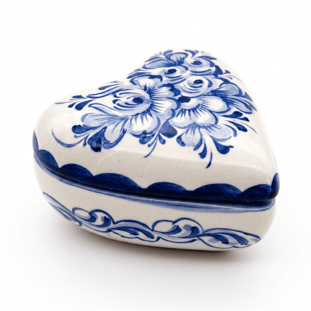 A heart-shaped ceramic keepsake box with a blue floral pattern on a white background, photographed on a clean white surface.