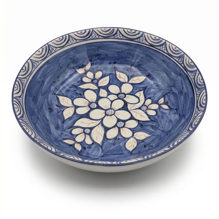 Decorative ceramic bowl with blue and white floral pattern on a white background