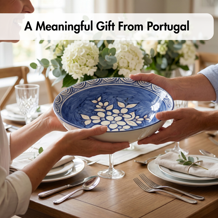 Two people holding a blue and white ceramic bowl with floral design on a dining table.