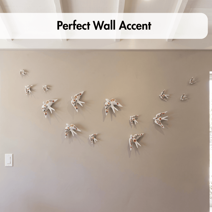 A set of decorative wall-mounted bird sculptures arranged in a flight pattern on a beige wall, with a white banner at the top reading &