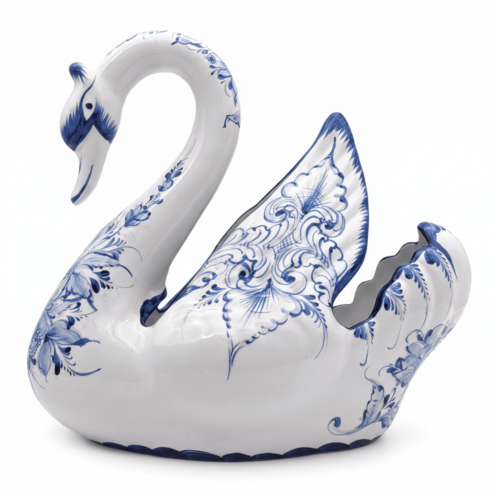 A white ceramic swan-shaped container or planter with intricate blue floral patterns, set against a plain white background.
