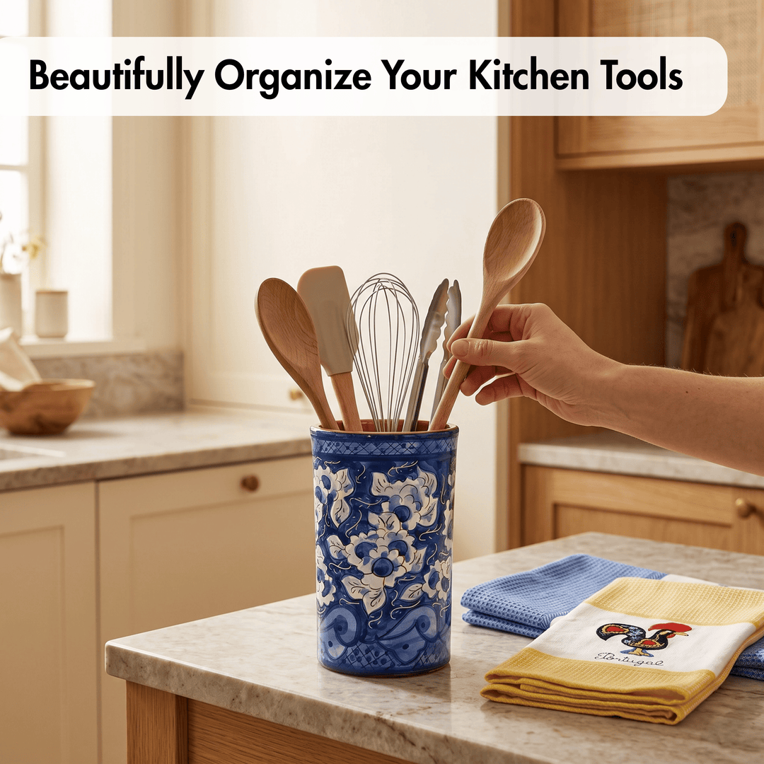 A blue ceramic kitchen utensil holder with white floral patterns sits on a kitchen counter, holding wooden spoons, spatulas, and a whisk. A hand is reaching for one of the wooden spoons.
