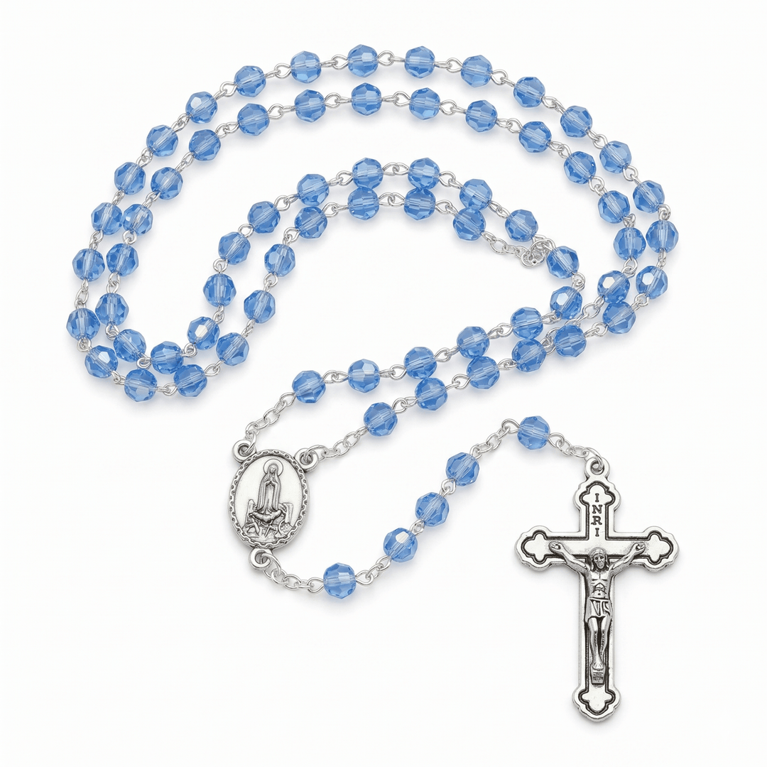 Blue rosary with silver crucifix and medal on a white background