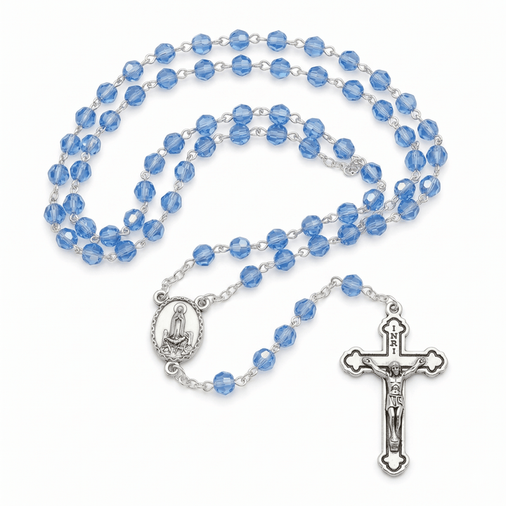 Blue rosary with silver crucifix and medal on a white background