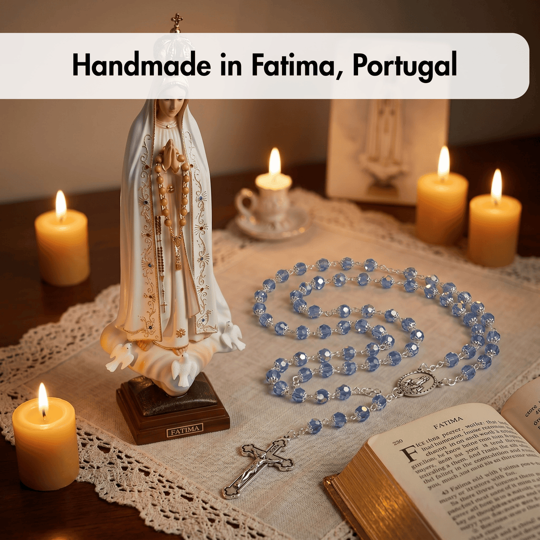 Statue of Our Lady of Fatima with rosary, candles, and open book on a lace tablecloth.