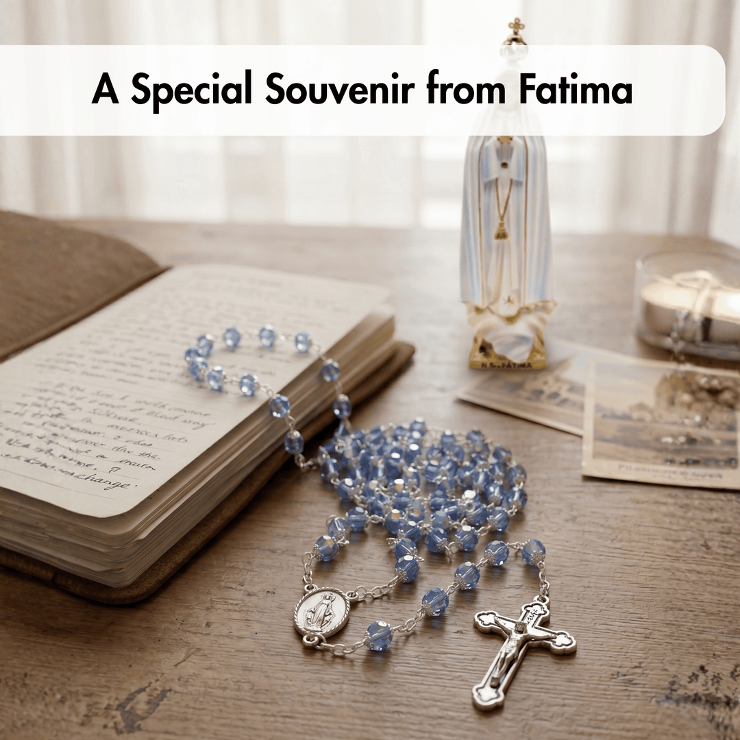 Blue rosary on an open book with a statue and candles in the background, labeled 'A Special Souvenir from Fatima'.