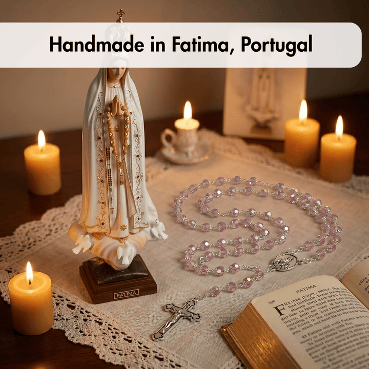 Statue of Our Lady of Fatima with a rosary and candles on a tablecloth, labeled 'Handmade in Fatima, Portugal'.