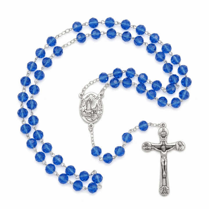 Blue rosary with silver crucifix and medal on a white background