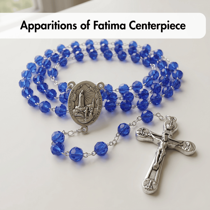 Blue rosary with a medal and cross on a white background, labeled 'Apparitions of Fatima Centerpiece'.