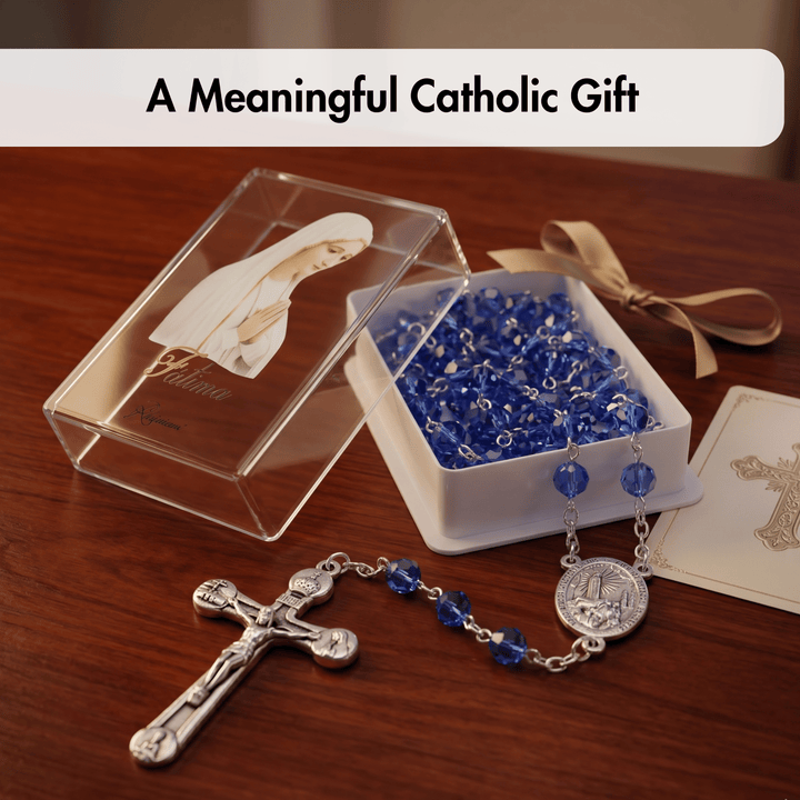 Catholic gift set with rosary, cross, and blue beads on a wooden surface.