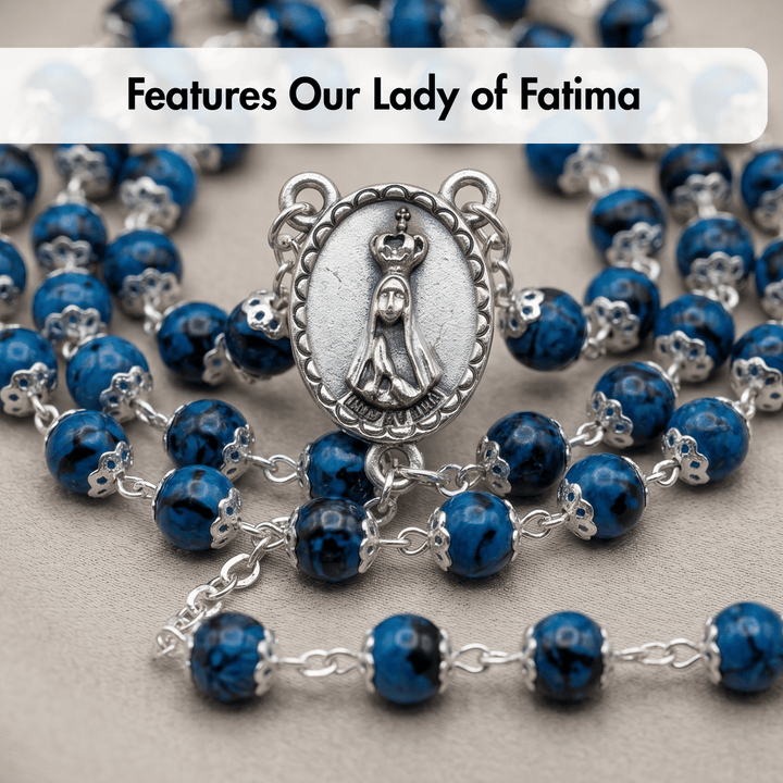 Blue rosary with Our Lady of Fatima medal on a gray background