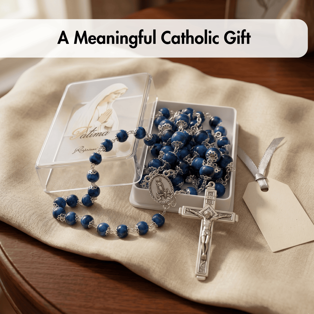 Blue rosary with silver crucifix in a clear box on a beige cloth, with text 'A Meaningful Catholic Gift'.