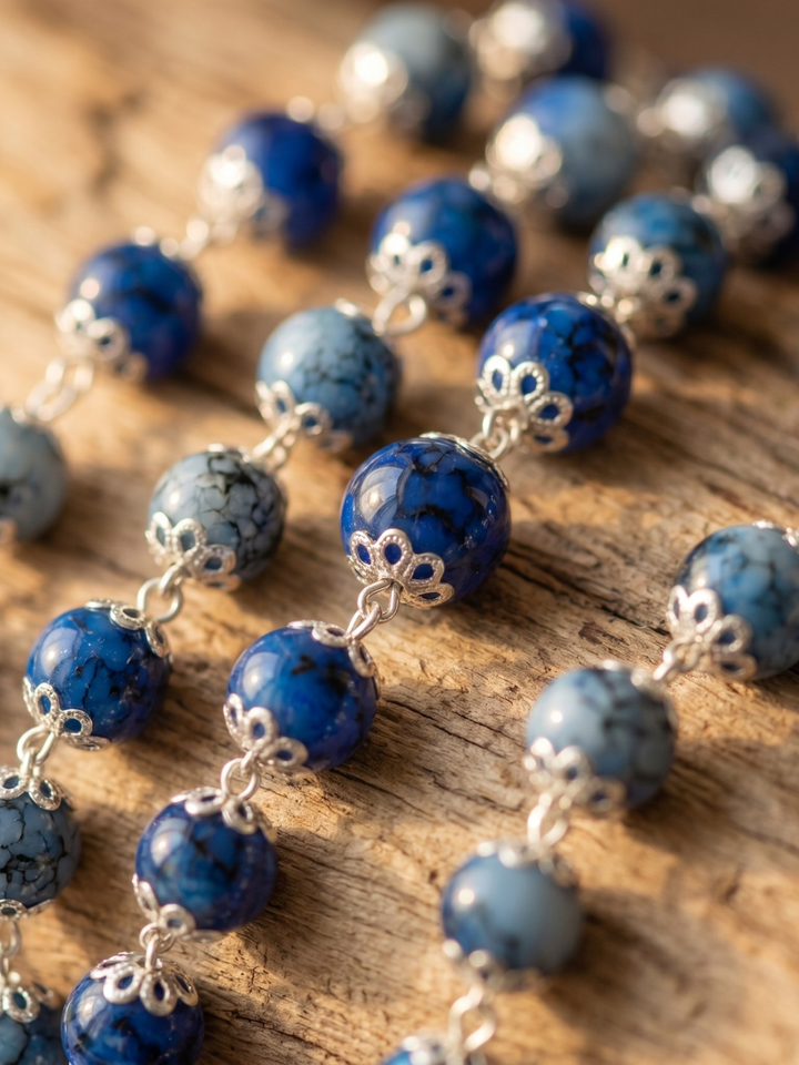 Blue beaded necklace with silver clasps on a wooden surface