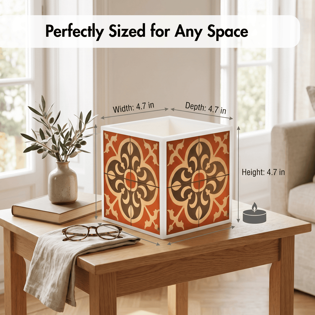 A decorative square box with a warm orange, brown, and beige floral tile pattern sits on a wooden table in a bright living room. White measurement arrows and text overlay the box, showing width, depth, and height as 4.