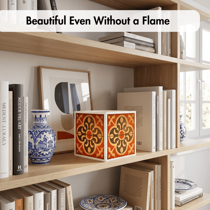 A decorative cube-shaped box with a red, orange, and black geometric tile pattern sits on a wooden bookshelf next to a blue-and-white ceramic vase and framed art. The text overlay at the top reads &