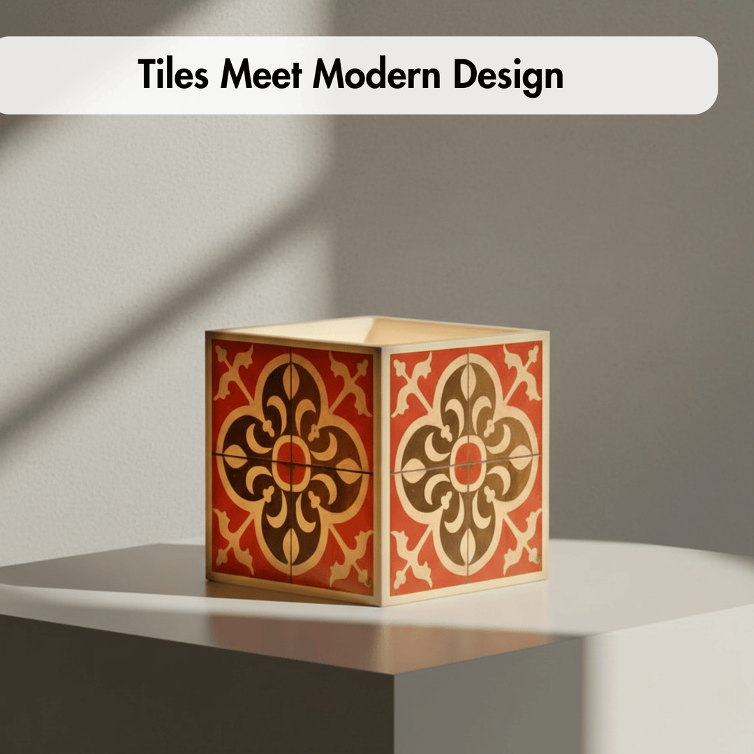 A decorative square box with a red, brown, and beige floral tile-inspired pattern sits on a white platform against a gray wall. A white banner at the top reads &