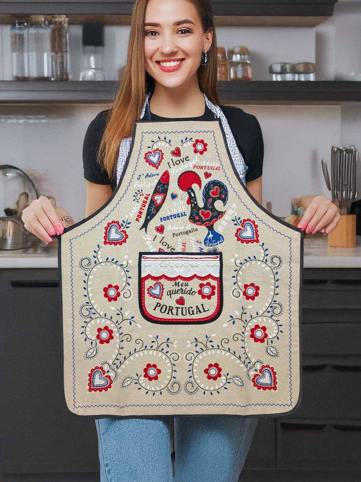 Person wearing a decorative apron with rooster design in a kitchen