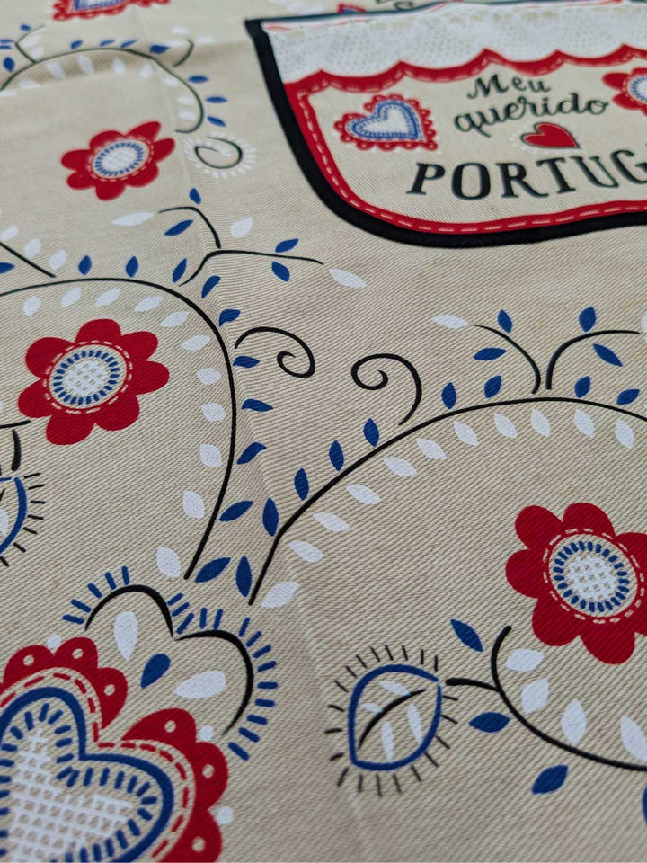 Textile with floral patterns and 'Meu querido Portugal' text on a beige background