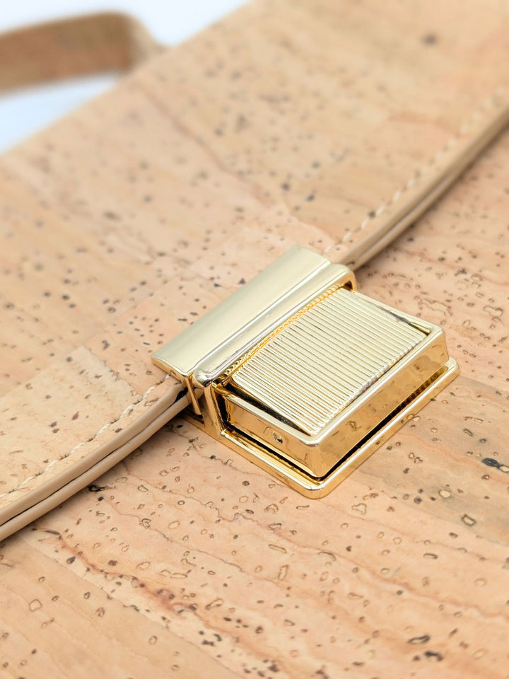 Close-up of a gold buckle on a cork-textured bag